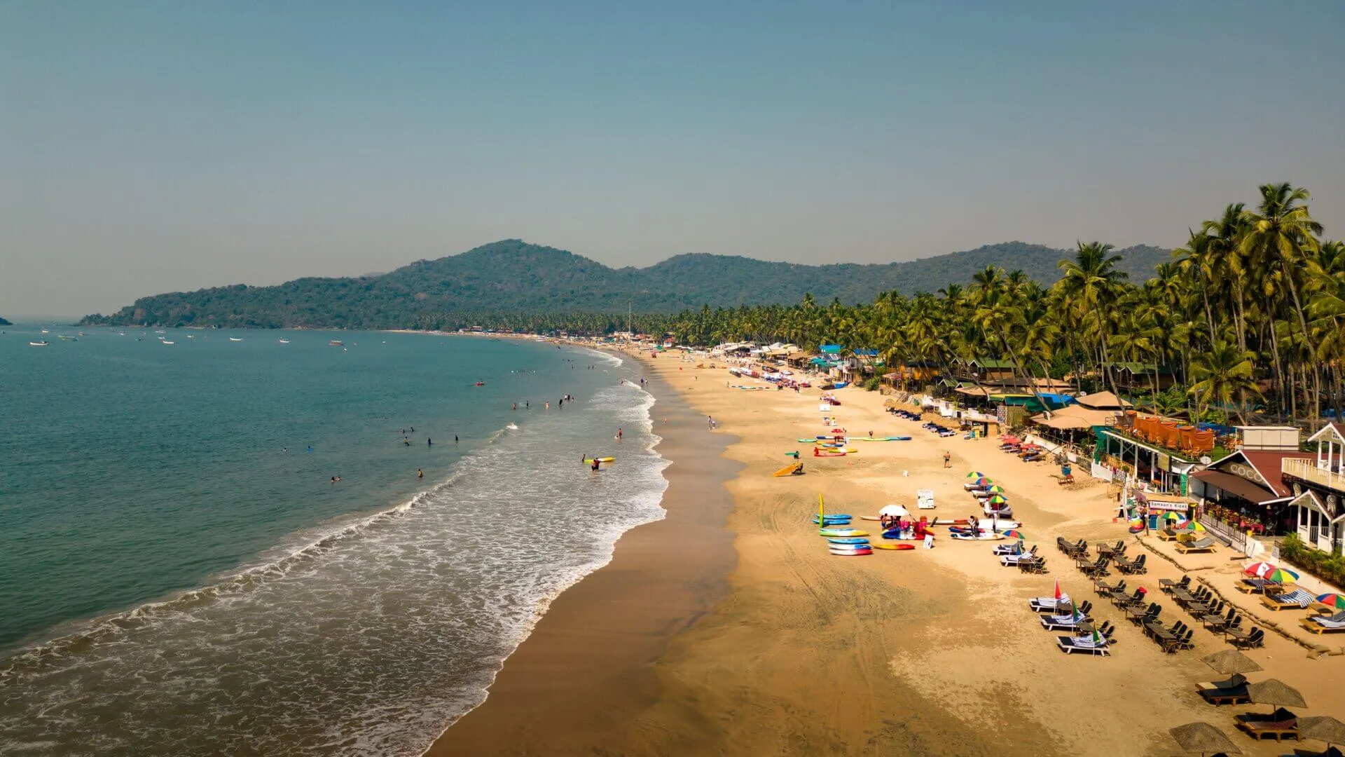 Calm turquoise waters and palm-fringed shoreline of Palolem Beach in South Goa